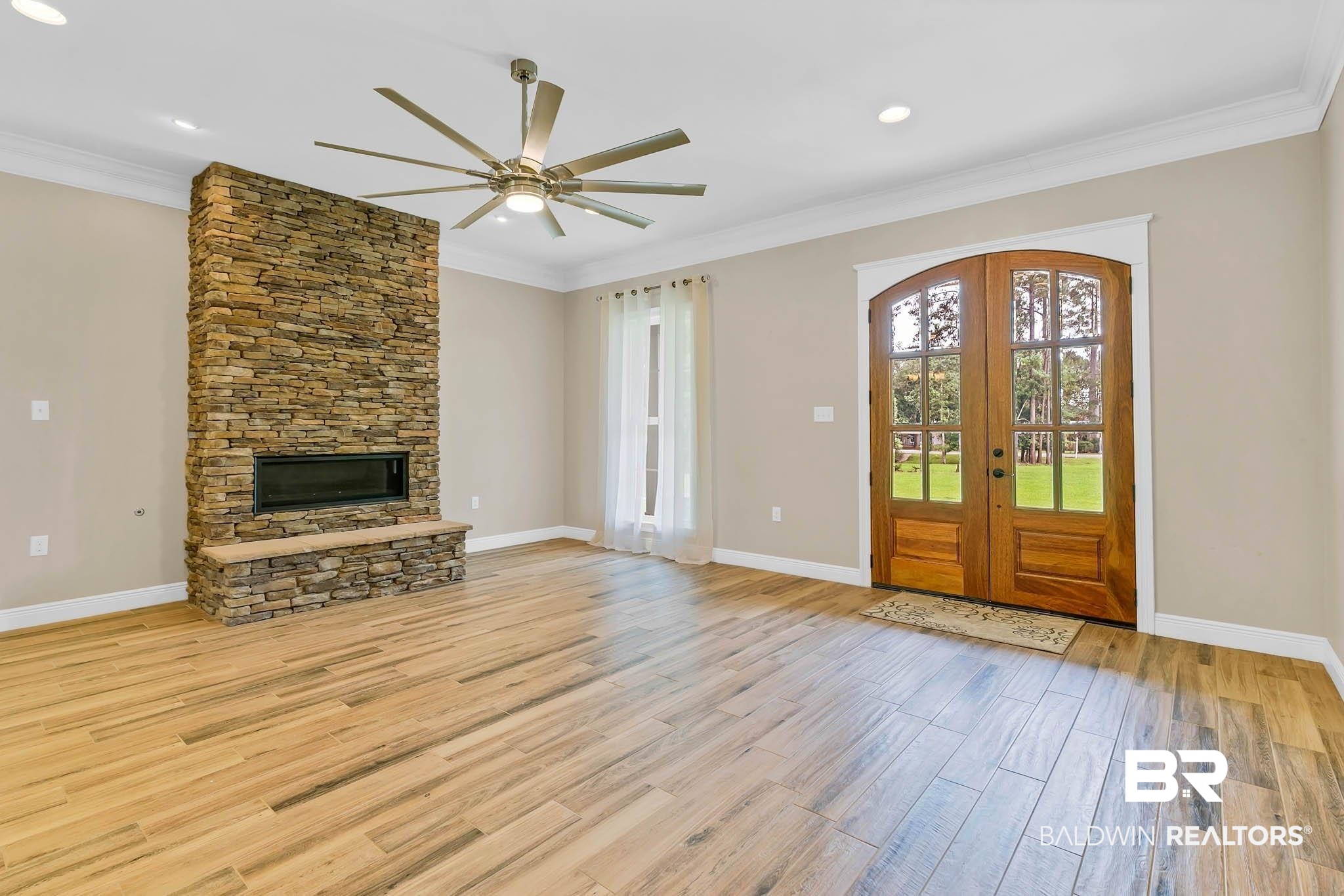 8145 Bay View Drive Foley, AL 36535 - Photo 7 of 81 Entryway with light wood-style flooring, a fireplace, a ceiling fan, crown molding, and french doors