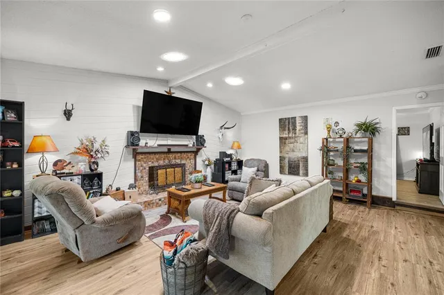 a living room with fireplace furniture and a flat screen tv