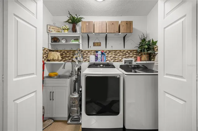 a utility room with sink dryer and washer
