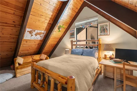 a bedroom with a bed and a flat tv screen next to a window