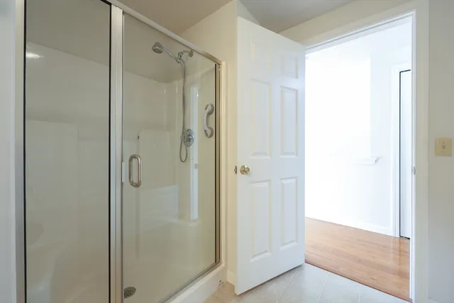 a white bath tub sitting next to a shower