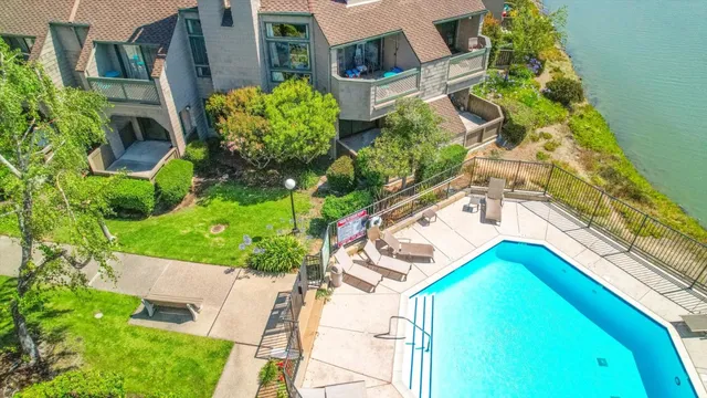 a view of a hallway with wooden floor and a bathroom