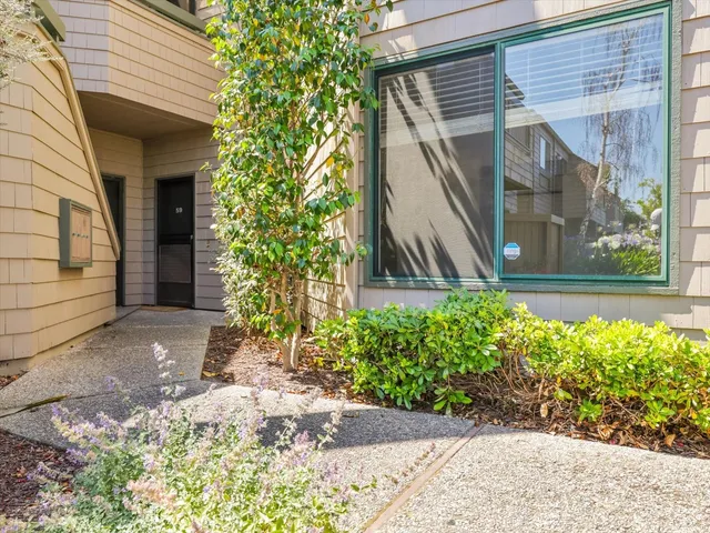 a view of a house with brick walls and a yard with plants