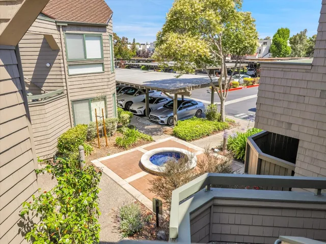 a view of a garden with a bench in front of house