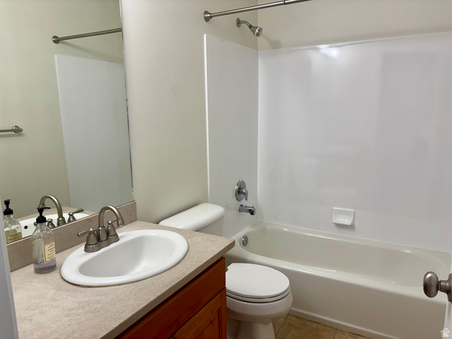 665 West State Road Lehi, UT 84043 - Photo 11 of 30 Bathroom featuring a white bathtub and shower surround, a vanity with an integrated sink, a light-toned countertop, and wood-finish cabinetry
