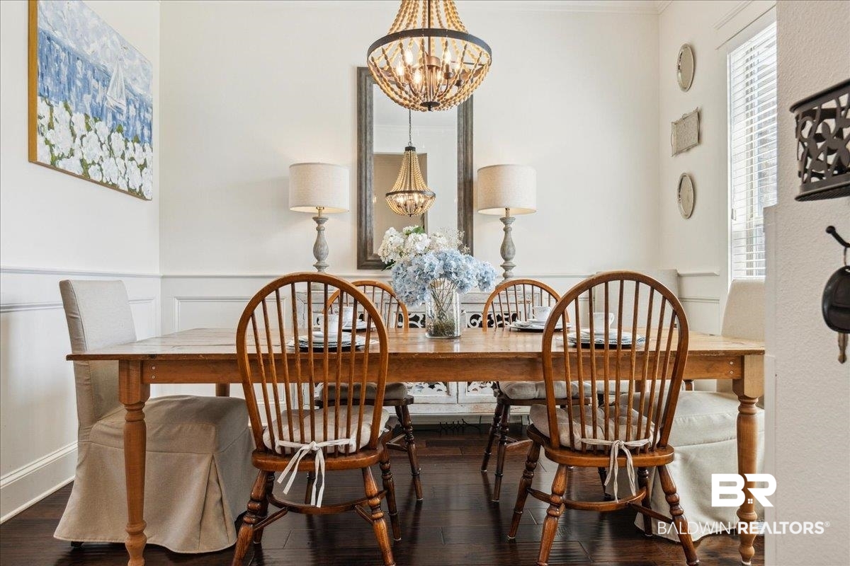 7088 Rocky Rd Loop Gulf Shores, AL 36542 - Photo 5 of 39 Dining space featuring a chandelier, wood finished floors, and a wainscoted wall