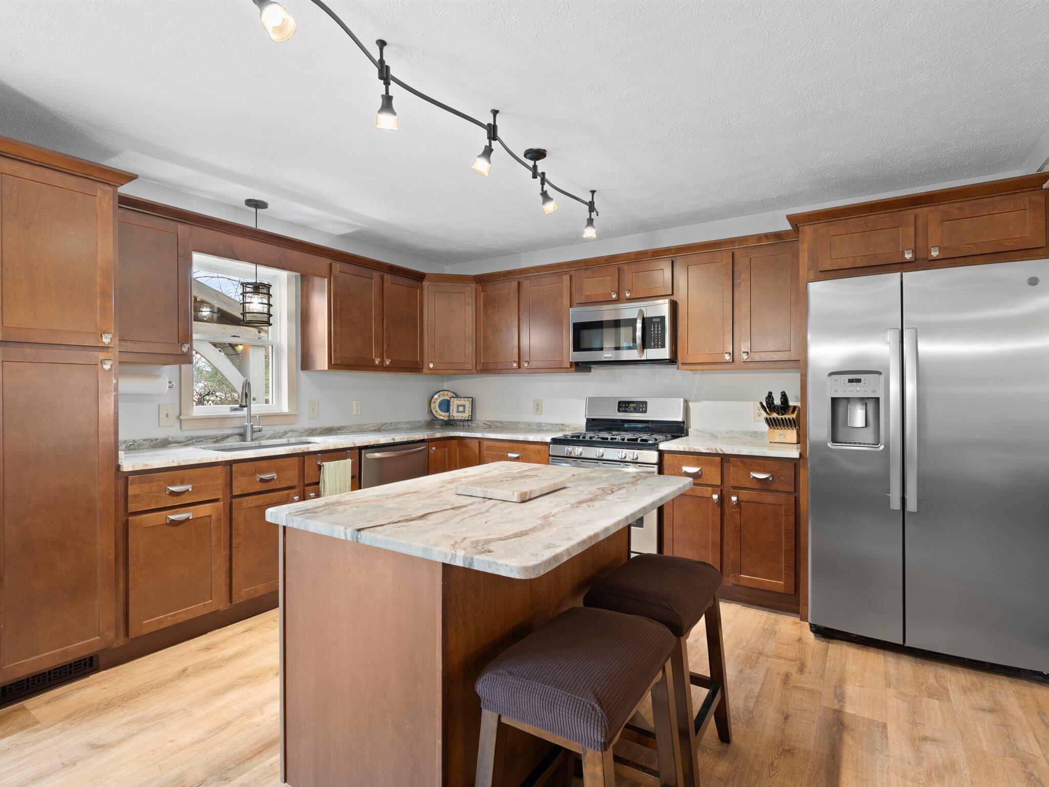 893 Pearson Road Chesterton, IN 46304 - Photo 6 of 30 a kitchen with a refrigerator a sink a stove a microwave and wooden cabinets