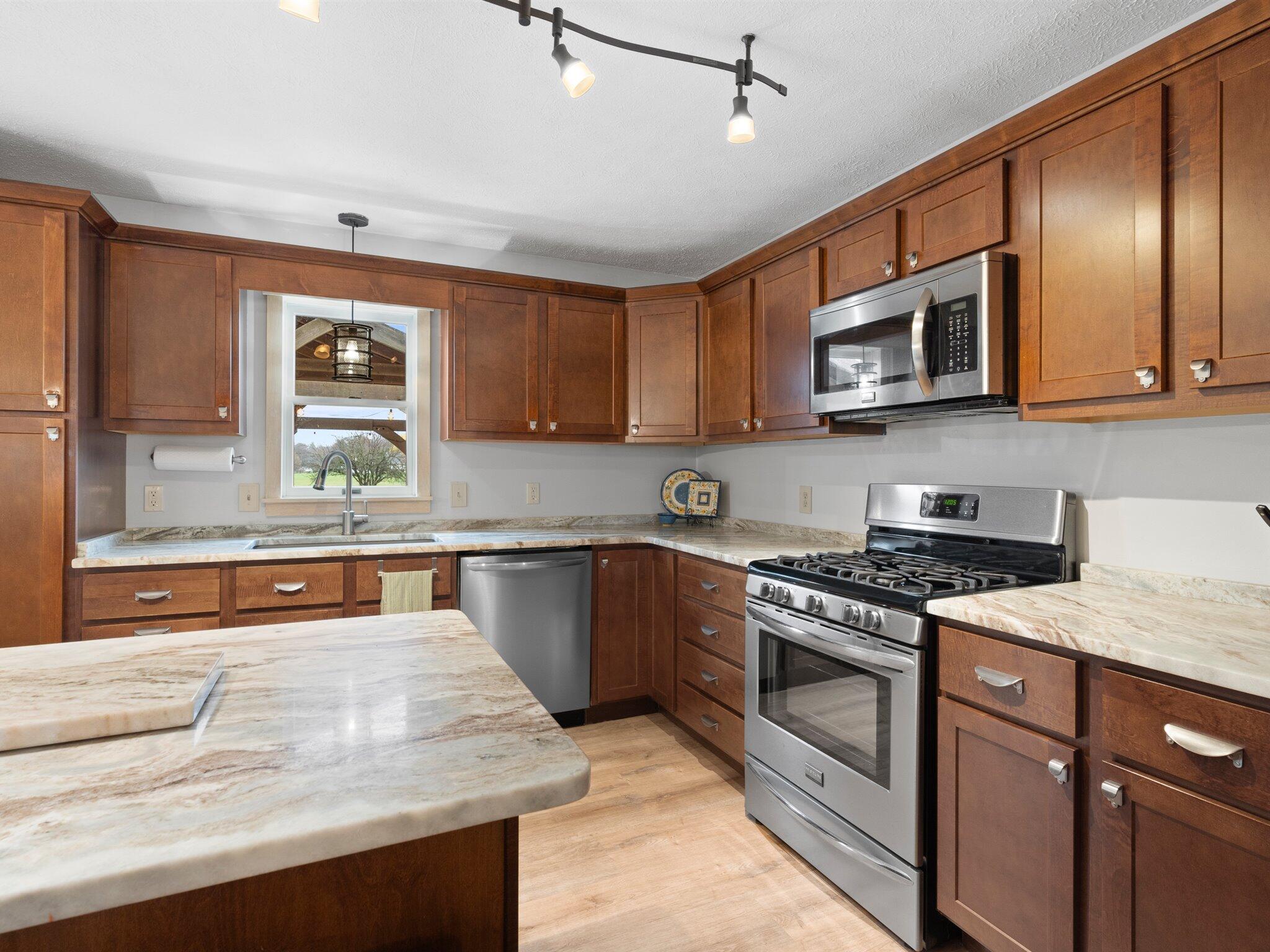 893 Pearson Road Chesterton, IN 46304 - Photo 7 of 30 a kitchen with stainless steel appliances granite countertop a stove a sink and a microwave