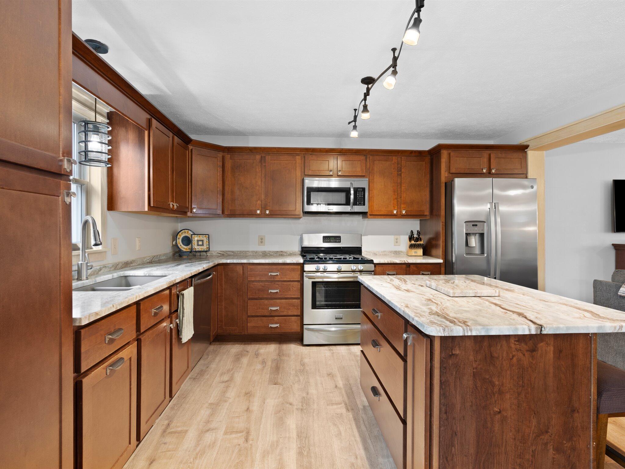 893 Pearson Road Chesterton, IN 46304 - Photo 8 of 30 a kitchen with stainless steel appliances granite countertop a sink a stove a refrigerator cabinets and a kitchen island