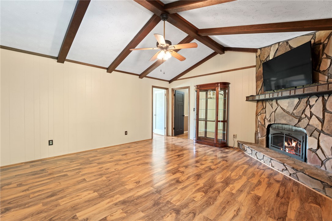200 Echo Circle Easley, SC 29642 - Photo 9 of 35 A striking stone fireplace with a rustic mantel anchors this inviting living space, crowned by a beamed vaulted ceiling.