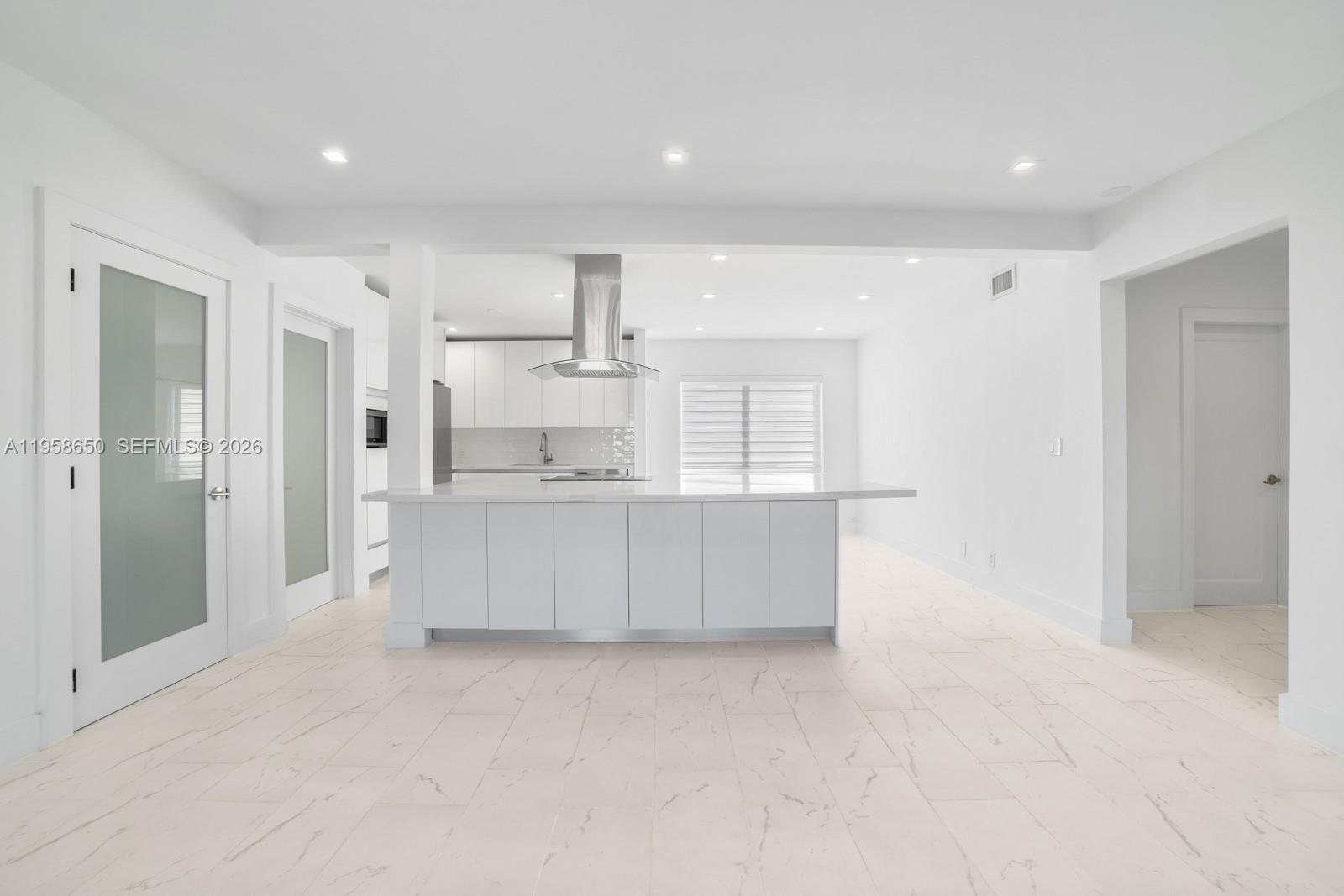3909 Garden Avenue, Unit 4 Miami Beach, FL 33140 - Photo 3 of 29 a view of kitchen with white cabinets and wooden floors