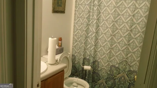 a bathroom with a granite countertop toilet and a sink