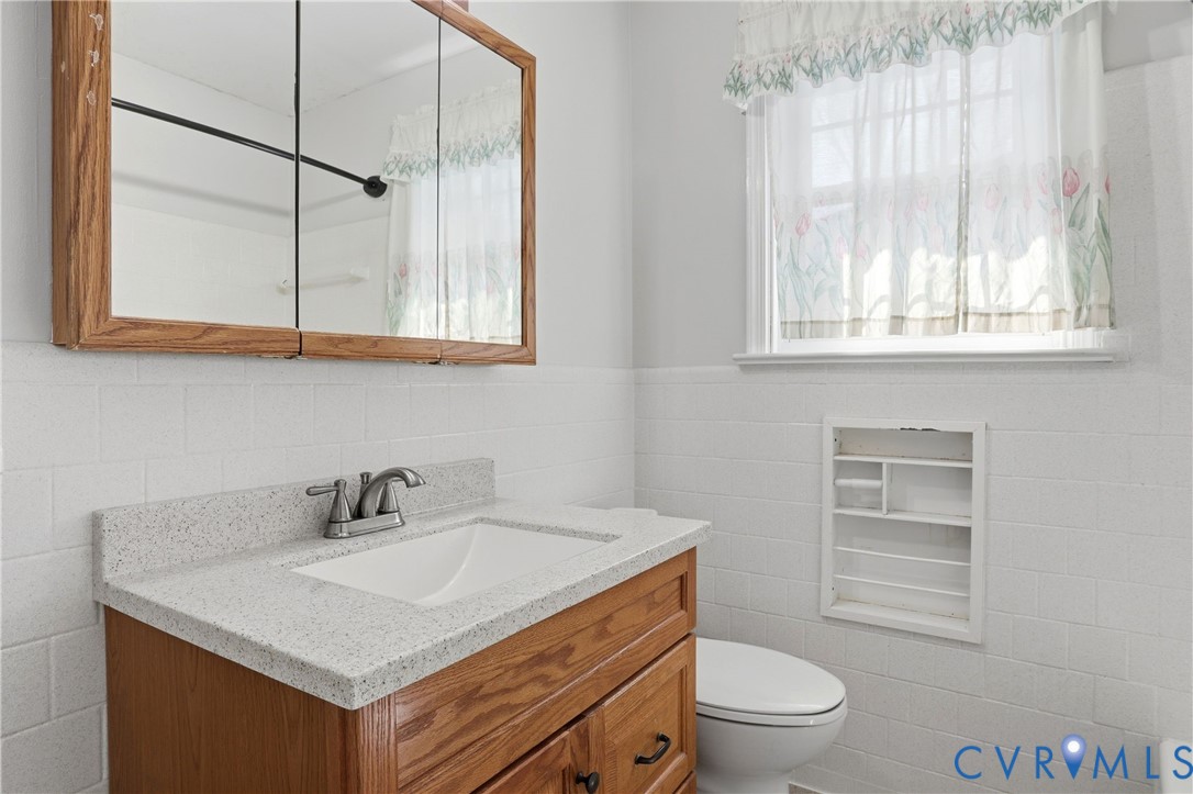 8421 Yolanda Road Henrico, VA 23229 - Photo 17 of 34 a bathroom with a sink a toilet and a window