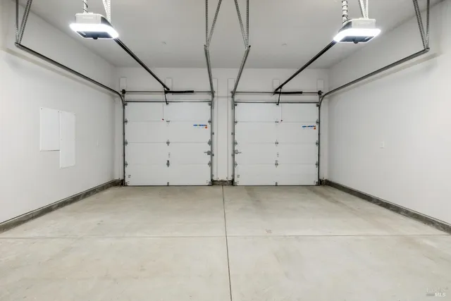 a sign that is sitting in front of a road with a house in the background