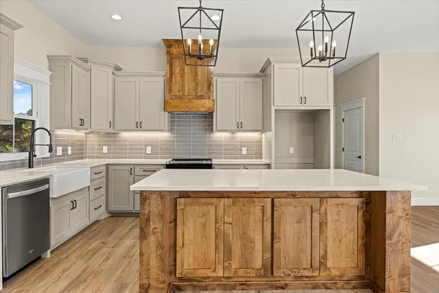 a kitchen with stainless steel appliances granite countertop a sink a stove and cabinets