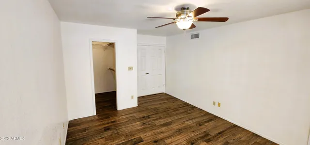 a view of a room with wooden floor and a ceiling fan