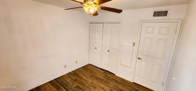 a view of a room with wooden floor and fan