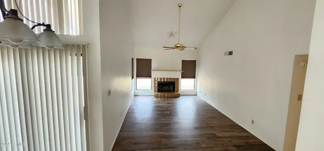 a view of a hallway with wooden floor fireplace and living room