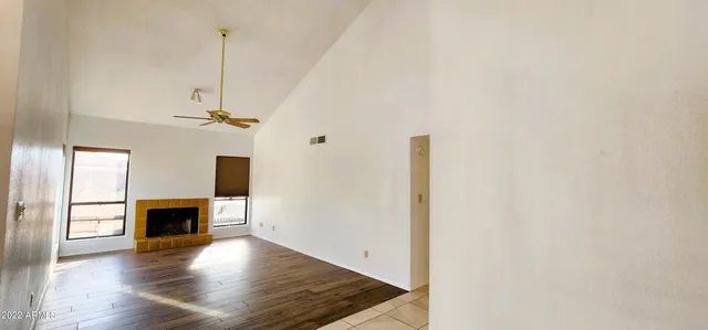 a view of a livingroom with wooden floor and a ceiling fan