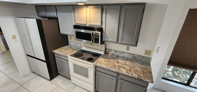 a kitchen with granite countertop a refrigerator and a stove