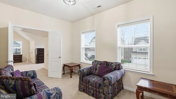 a living room with furniture and wall paintings