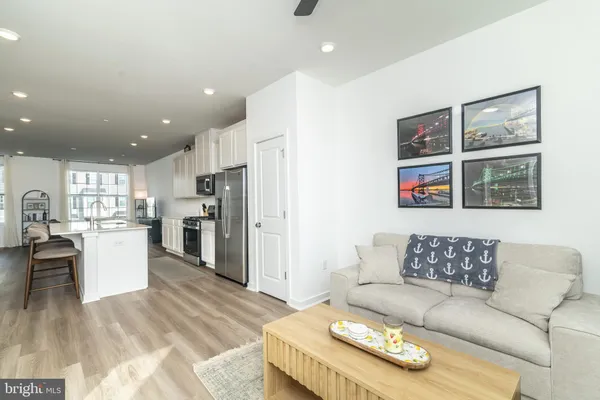 a living room with furniture and kitchen view