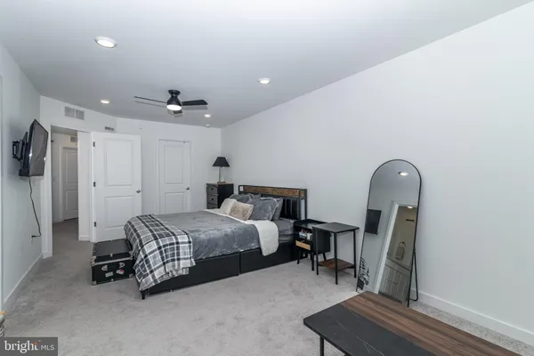 a spacious bedroom with a bed a couch and a chandelier