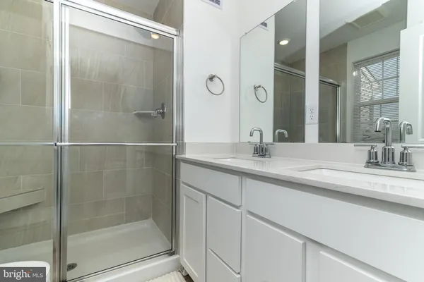 a bathroom with a shower sink and mirror