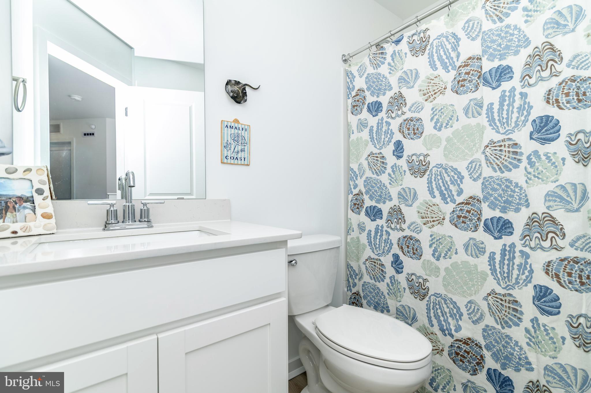 41 Barnes Way Sicklerville, NJ 08081 - Photo 40 of 46 a bathroom with a granite countertop toilet a sink a mirror and a shower curtain