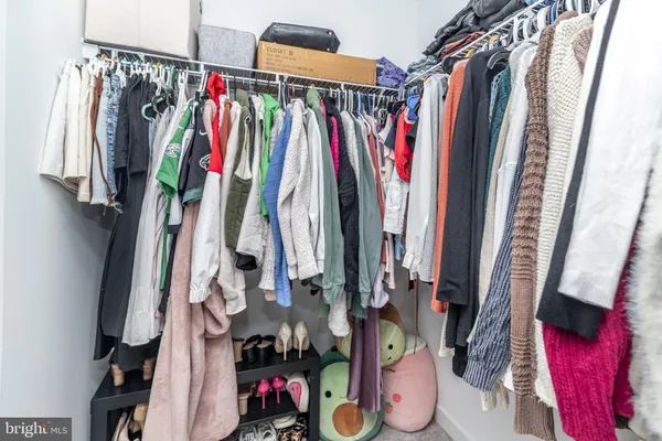 a view of walk in closet with clothes