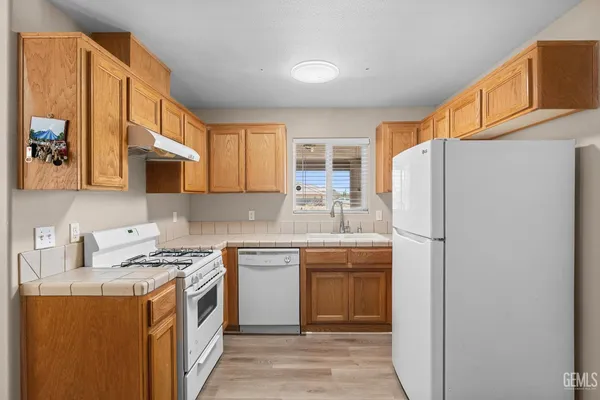 a kitchen with stainless steel appliances granite countertop a refrigerator sink stove and microwave