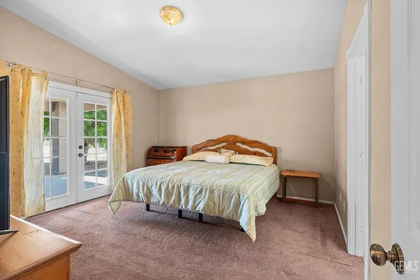a bedroom with a bed and large windows