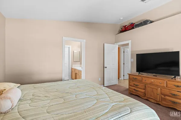 a bedroom with a flat screen tv and a bed