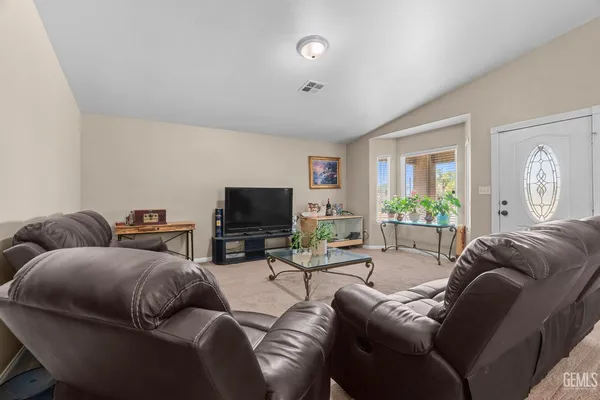 a living room with furniture a flat screen tv and a large window