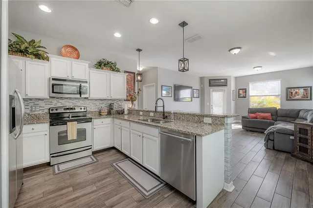 a kitchen with granite countertop cabinets stove top oven and microwave