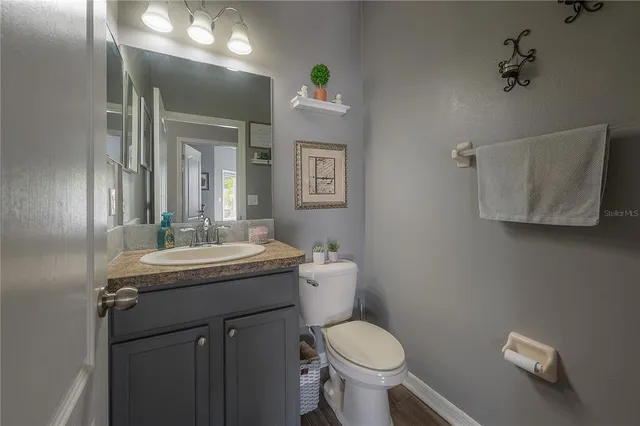 a bathroom with a granite countertop toilet sink and mirror
