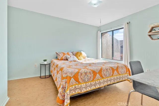 a bedroom with a bed and a lamp on dresser