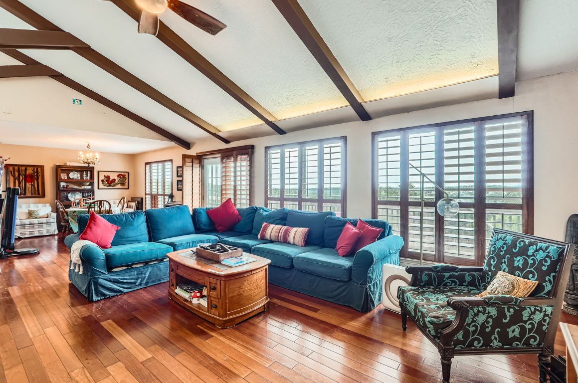 Living room featuring a chandelier, hardwood / wood-style flooring, a ceiling fan, and a textured ceiling
