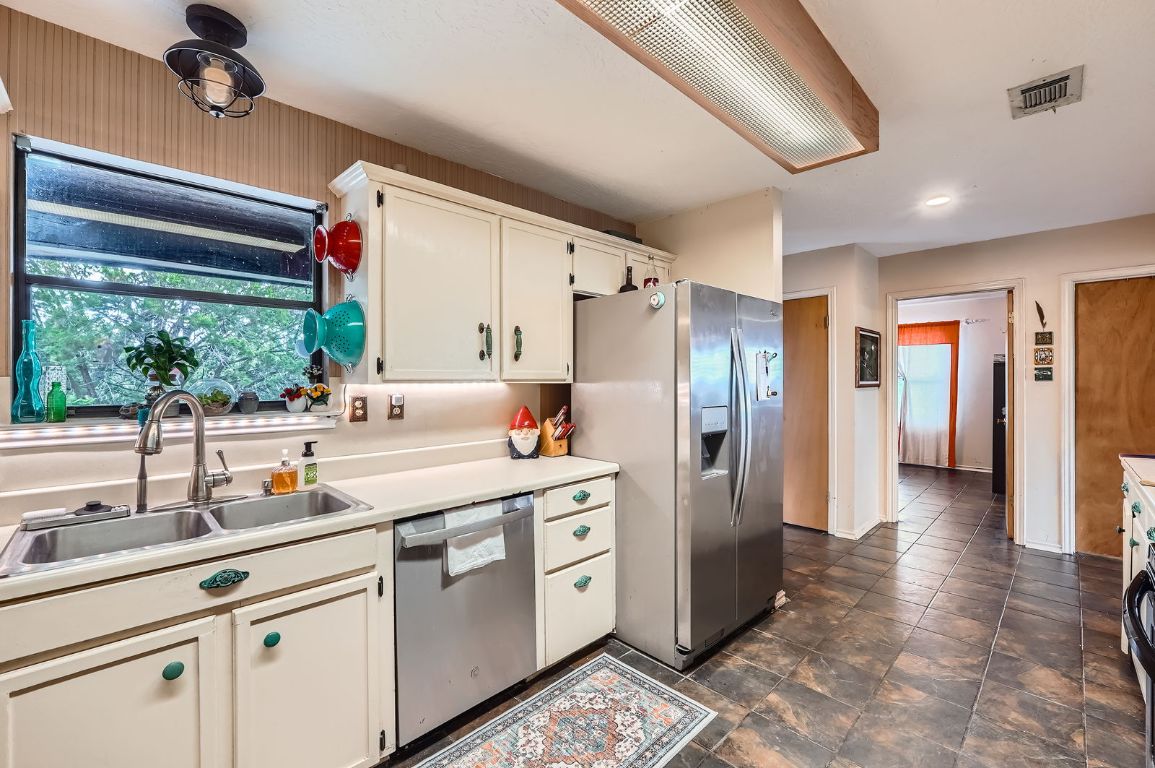 760 Skyline Ridge Lookout Wimberley, TX 78676 - Photo 12 of 40 Kitchen featuring appliances with stainless steel finishes, white cabinetry, and light countertops