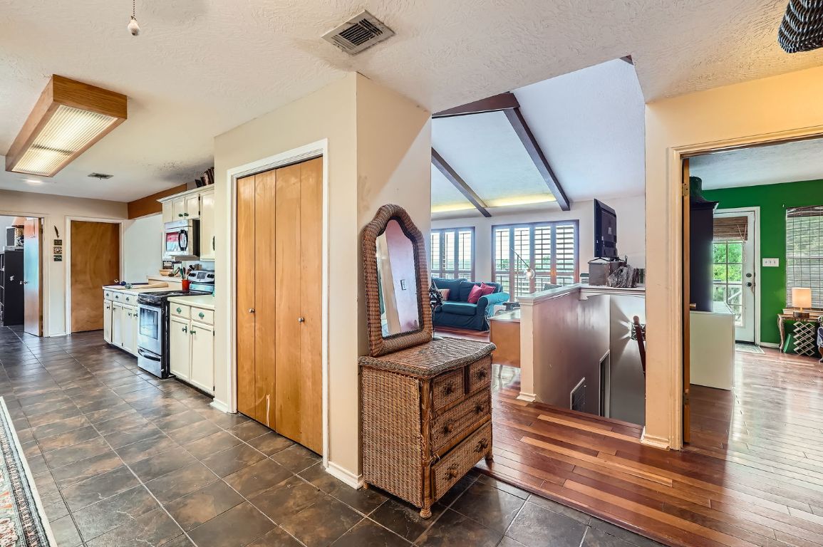 760 Skyline Ridge Lookout Wimberley, TX 78676 - Photo 14 of 40 Kitchen featuring stainless steel appliances, white cabinets, plenty of natural light, and a textured ceiling
