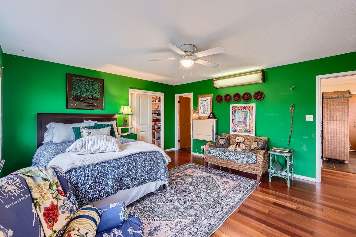760 Skyline Ridge Lookout Wimberley, TX 78676 - Photo 20 of 40 Bedroom with a wall mounted AC, wood finished floors, and ceiling fan