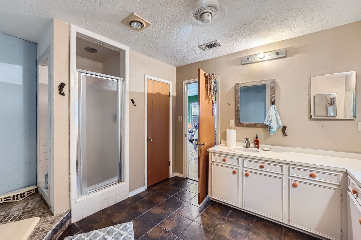 760 Skyline Ridge Lookout Wimberley, TX 78676 - Photo 24 of 40 Full bath with vanity, a stall shower, and a textured ceiling