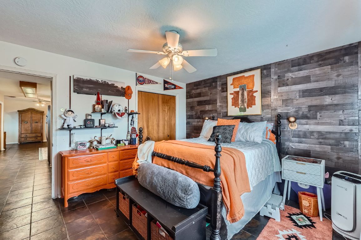 760 Skyline Ridge Lookout Wimberley, TX 78676 - Photo 26 of 40 Bedroom featuring wooden walls and a ceiling fan