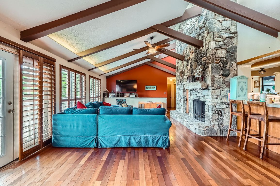 760 Skyline Ridge Lookout Wimberley, TX 78676 - Photo 4 of 40 Living room with hardwood / wood-style flooring, a ceiling fan, and a fireplace