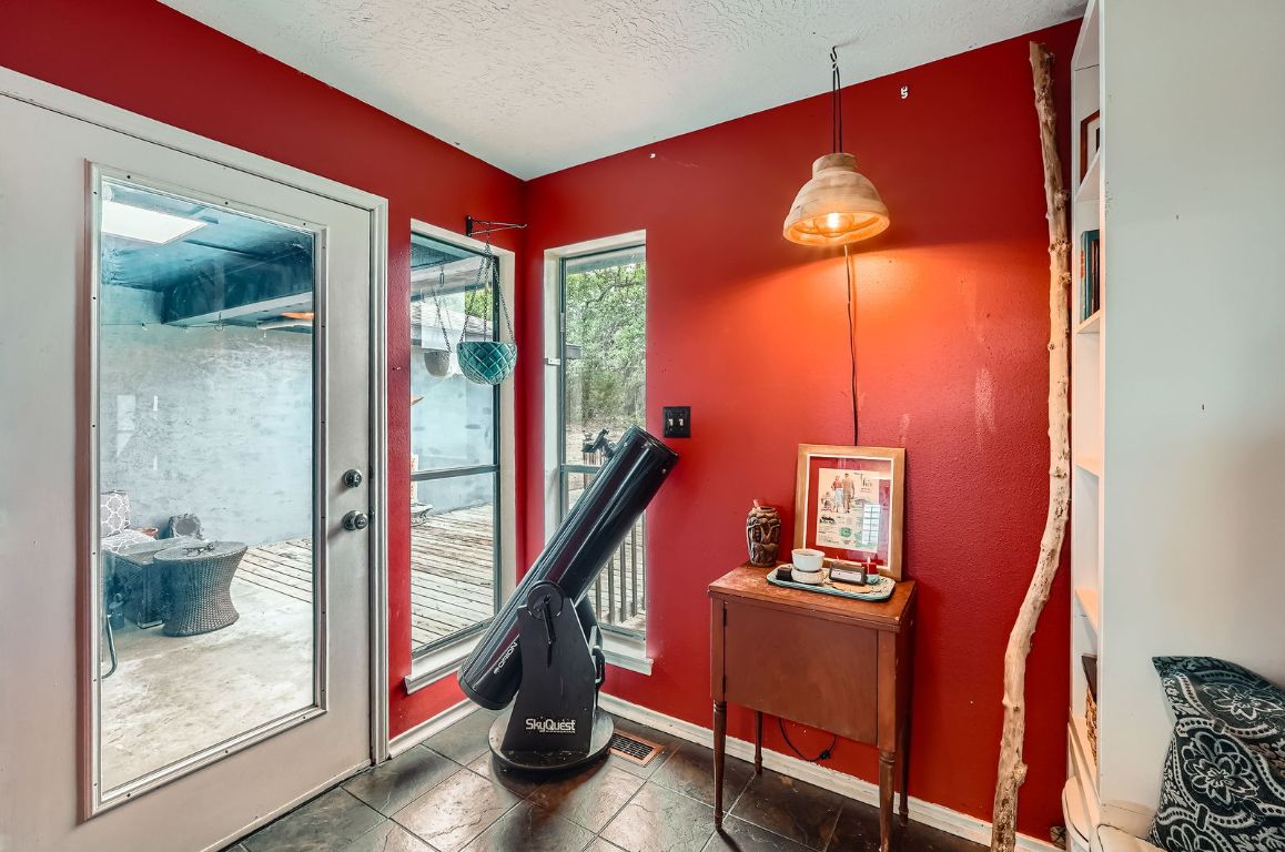 760 Skyline Ridge Lookout Wimberley, TX 78676 - Photo 7 of 40 Doorway to outside featuring a textured ceiling and baseboards
