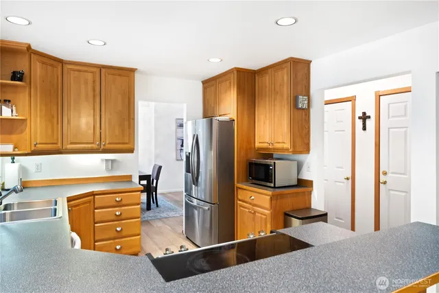 a kitchen with stainless steel appliances granite countertop a refrigerator and a stove top oven