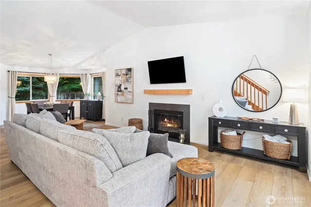 a living room with furniture a fireplace a flat screen tv and a large window