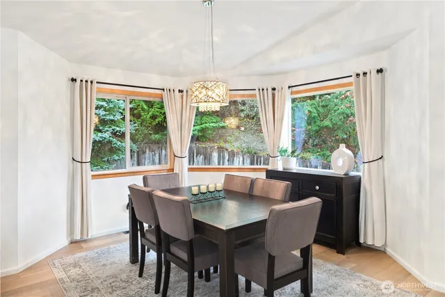 a dining room with furniture a chandelier and wooden floor