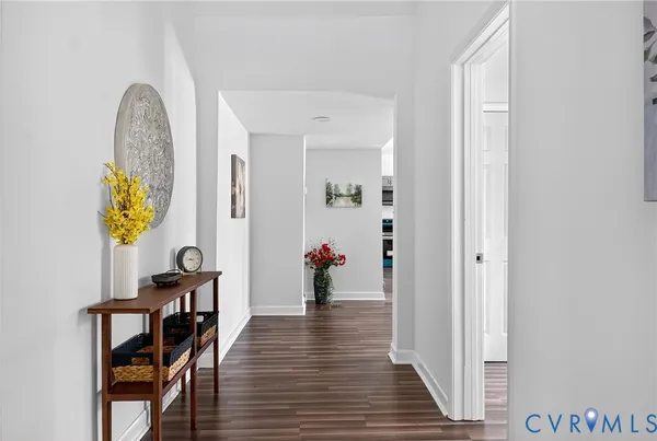 a kitchen with stainless steel appliances granite countertop a stove top oven a sink a dining table and chairs with wooden floor