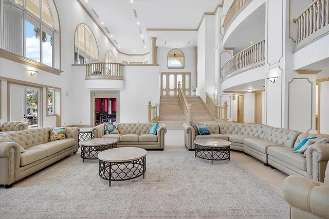 a living room with furniture kitchen view and a chandelier